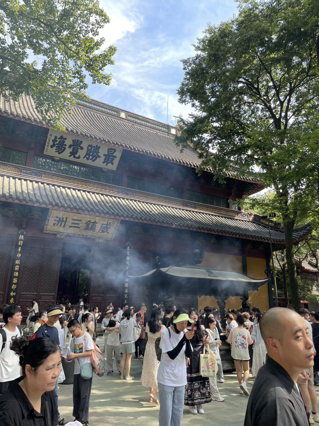 線香の煙が立ちこめる霊隠寺の本堂前と参拝客