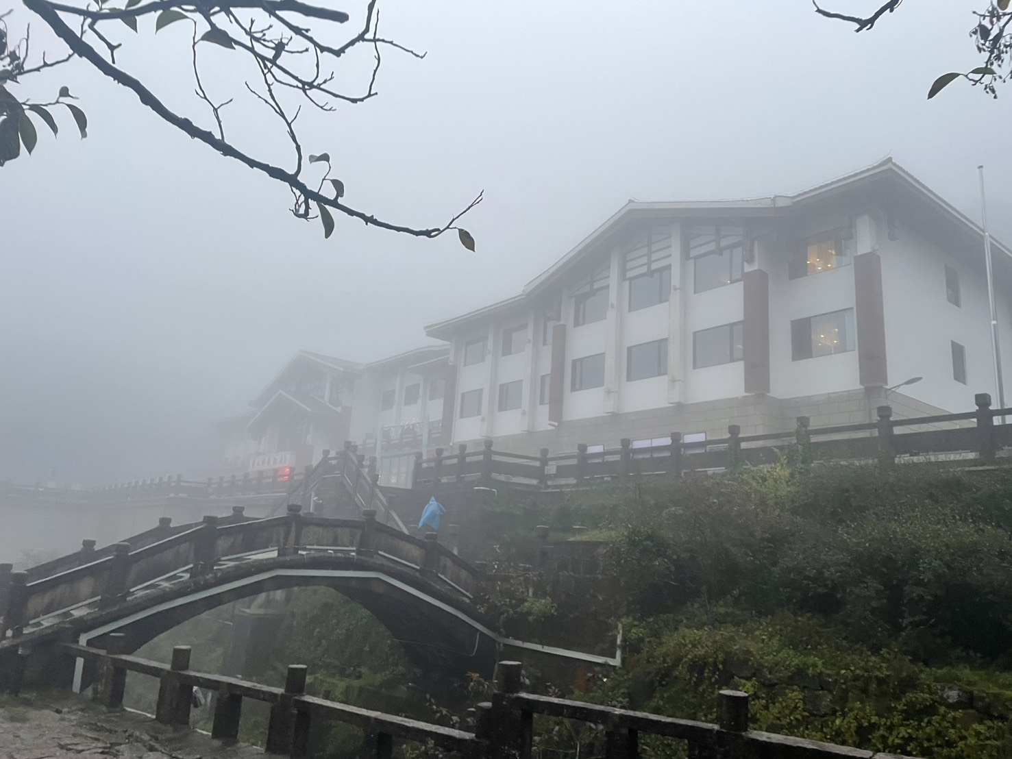 霧に包まれた黄山西海飯店の建物と手前の石橋